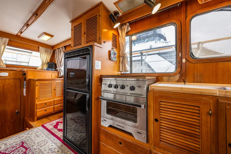 Slide: The Image of 1986 Kha Shing 37' yacht interior with wood cabinetry and kitchen appliances. - 28
