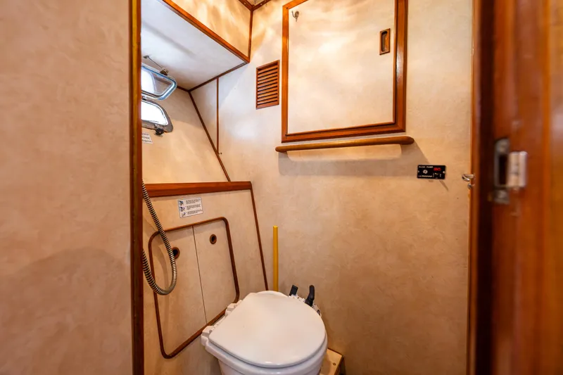 Slide: The Image of Bathroom interior of a 1986 Kha Shing 37' yacht, featuring a compact toilet. - 29