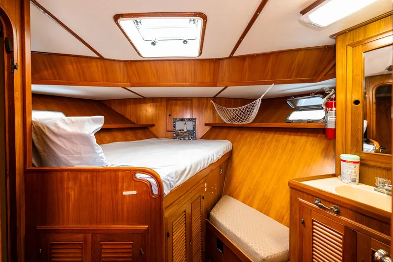 Slide: The Image of 1986 Kha Shing 37' yacht cabin with wooden interior, bed, and storage. - 34