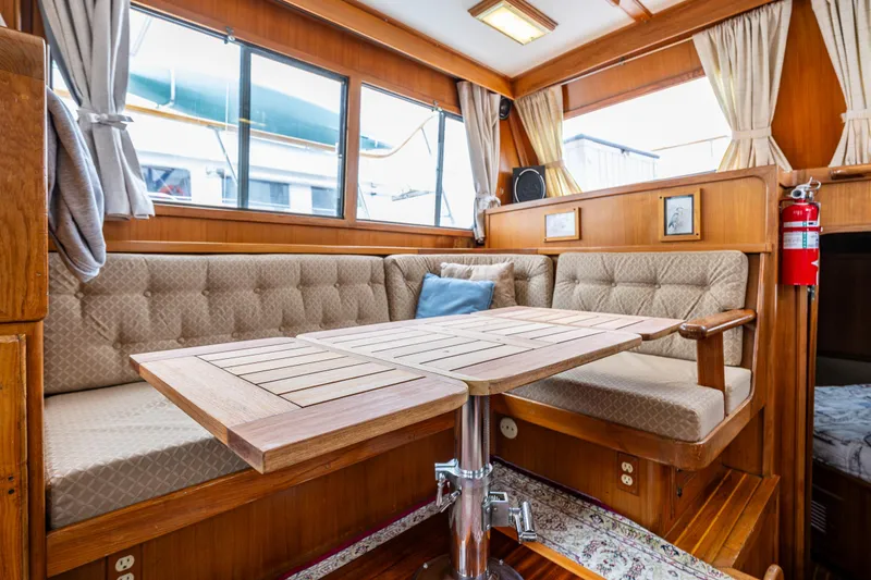 Slide: The Image of Cozy interior of 1986 Kha Shing 37' yacht with wooden table and cushioned seating. - 36
