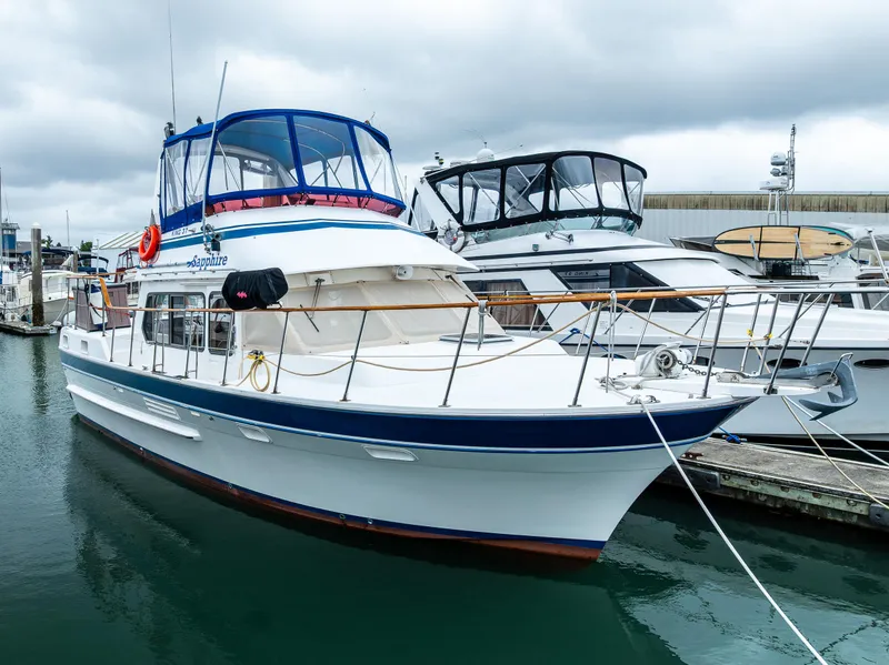 Slide: The Image of 1986 Kha Shing 37' yacht docked at marina under cloudy skies. - 4