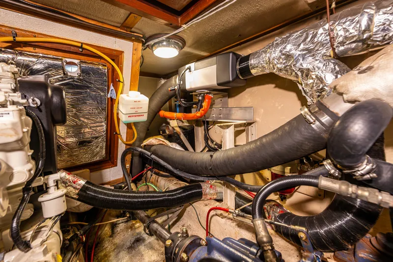 Slide: The Image of Engine room of 1986 Kha Shing 37' yacht with visible pipes and machinery. - 40