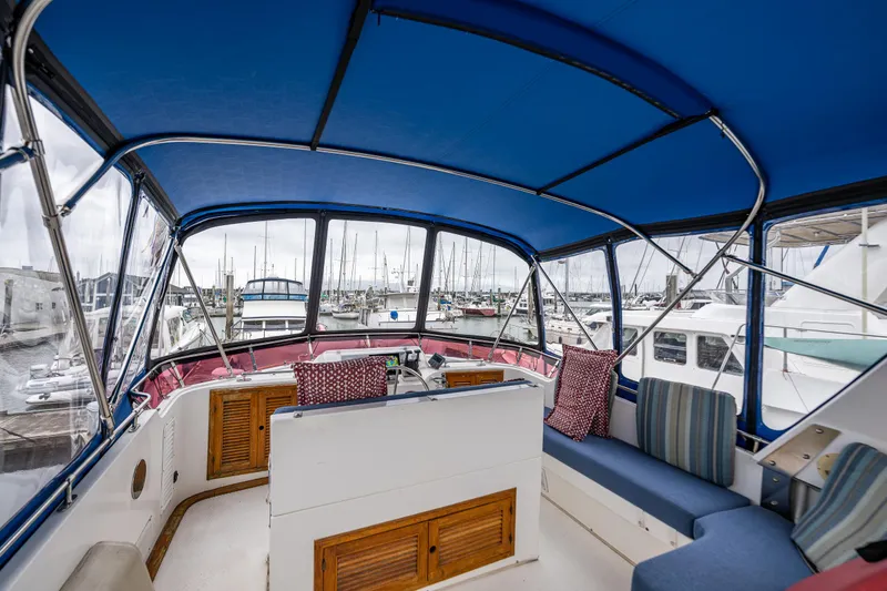 Slide: The Image of 1986 Kha Shing 37' yacht interior with blue canopy and marina view. - 43