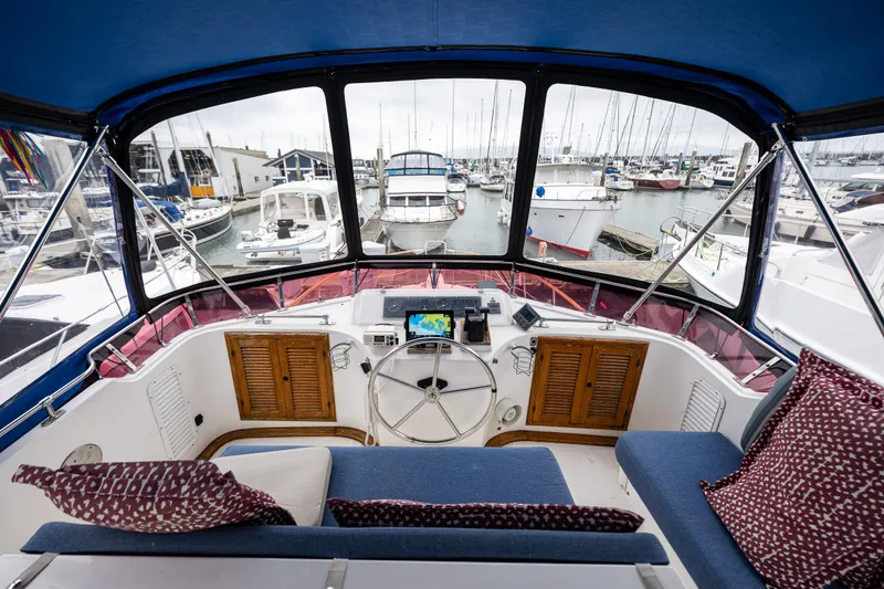 Slide: The Image of Interior view of 1986 Kha Shing 37' yacht cockpit with marina background. - 44