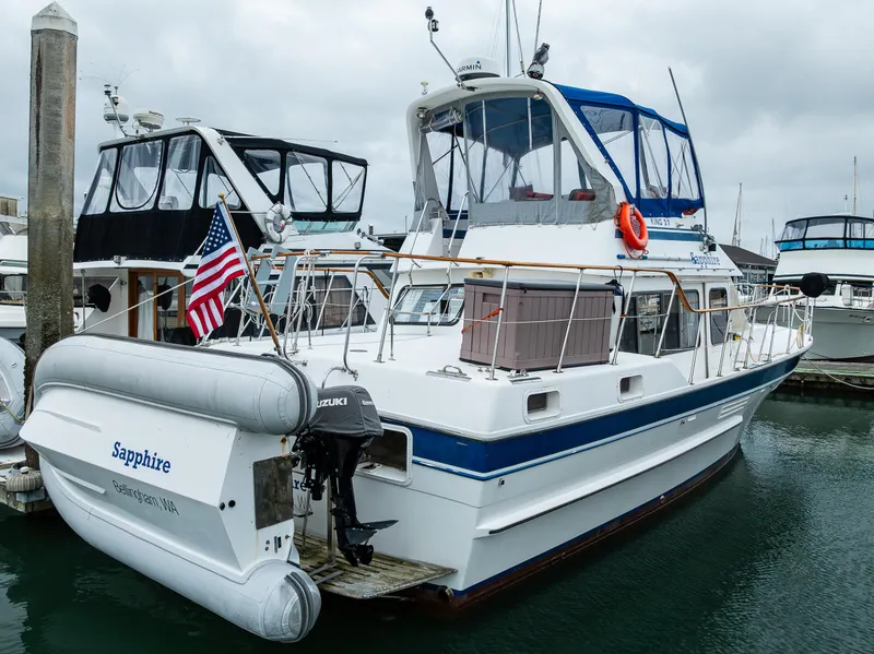 Slide: The Image of 1986 Kha Shing 37' yacht docked, featuring a blue canopy and American flag. - 5
