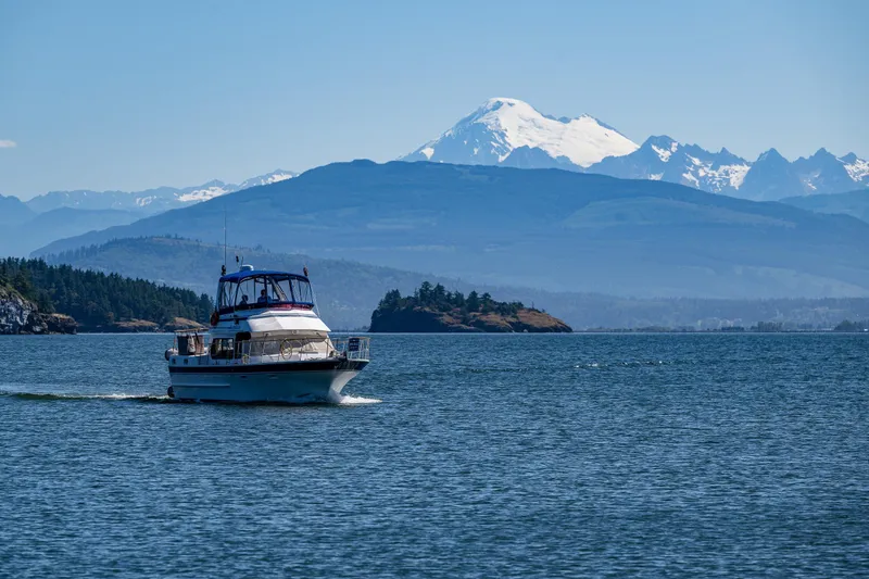 Slide: The Image of 1986 Kha Shing 37' yacht cruising on a scenic lake with mountains in the background. - 6