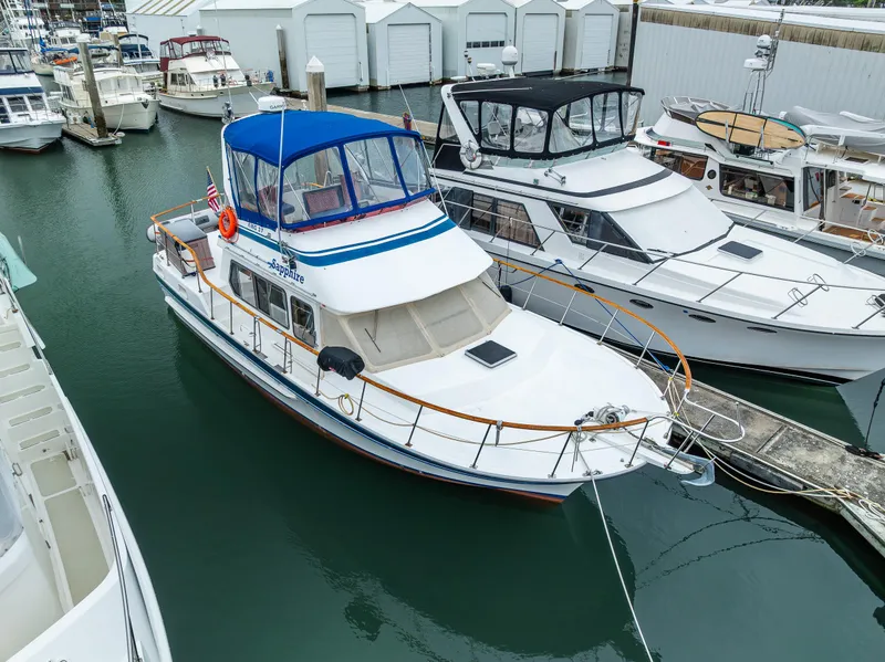 Slide: The Image of 1986 Kha Shing 37' yacht docked in marina, featuring blue canopy and white hull. - 7