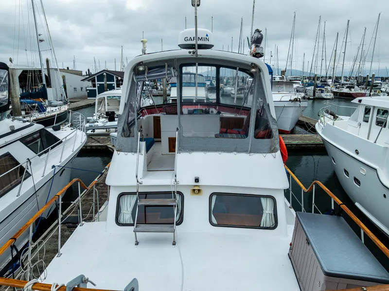 Slide: The Image of 1986 Kha Shing 37' yacht docked at a marina with surrounding boats. - 9