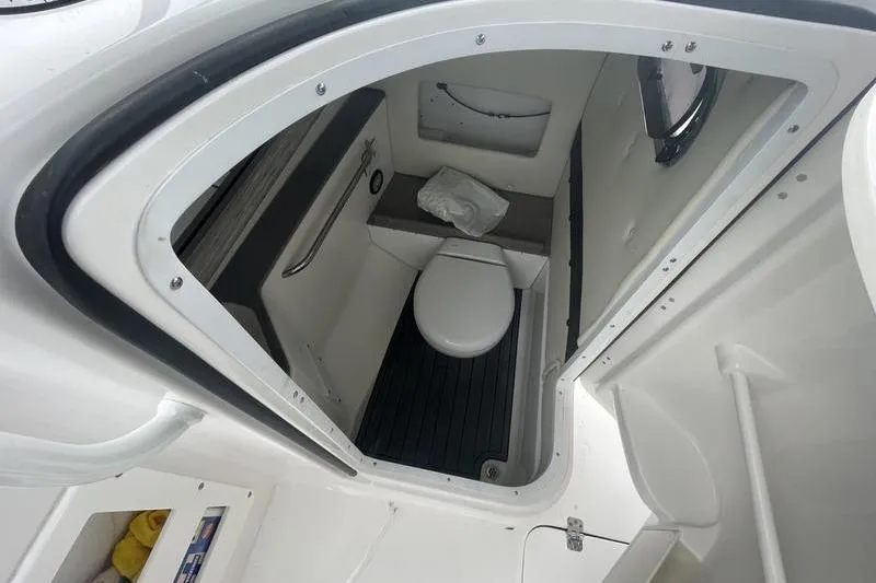 Slide: The Image of 2024 Edgewater 248CX boat interior bathroom with toilet and compact design. - 10