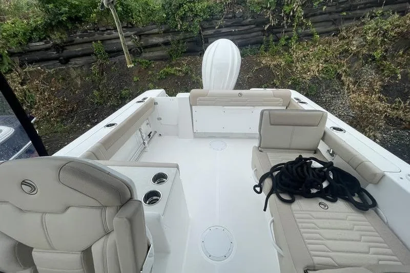 Slide: The Image of 2024 Edgewater 248CX boat interior with beige seating and cup holders. - 8