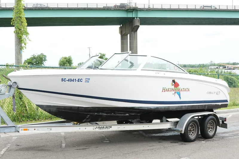 Slide: The Image of 2018 Cobalt 220S boat on trailer, parked under a bridge. - 11