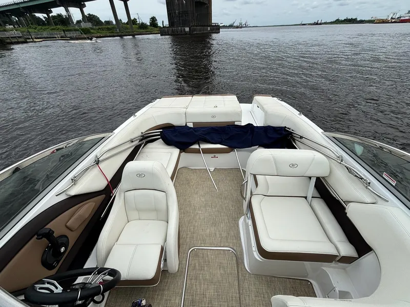 Slide: The Image of 2018 Cobalt 220S boat interior with white seating, on a calm river near a bridge. - 13