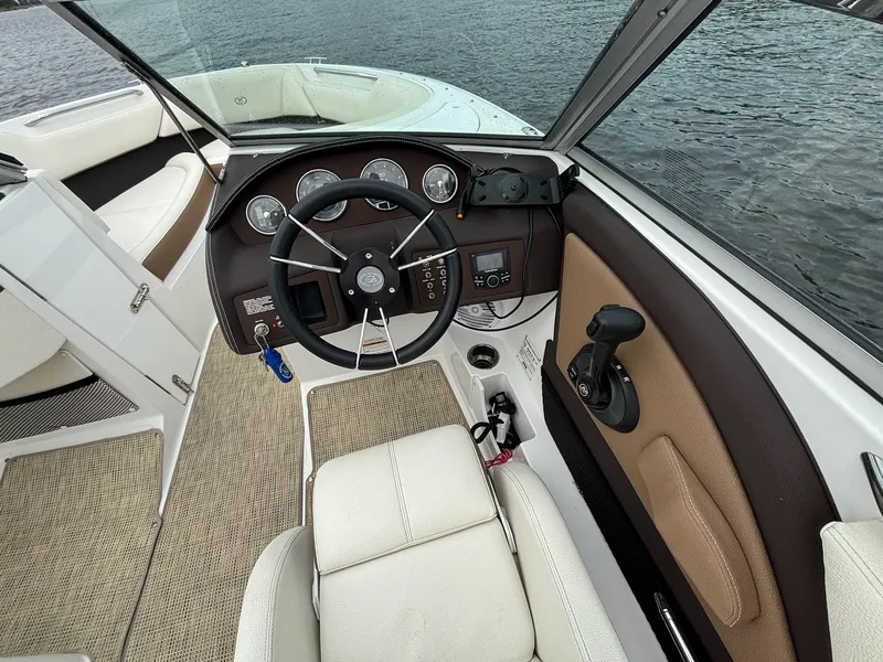 Slide: The Image of 2018 Cobalt 220S boat interior with steering wheel and controls, overlooking water. - 4
