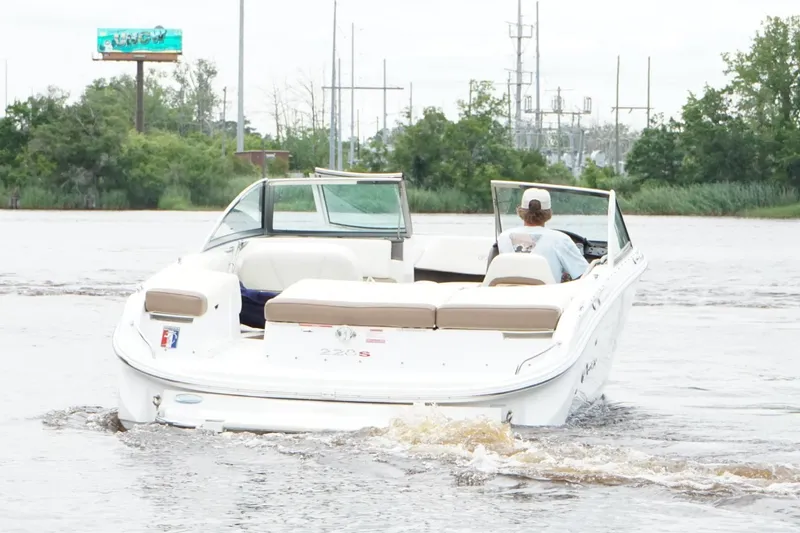 Slide: The Image of 2018 Cobalt 220S boat cruising on a river with lush greenery in the background. - 6