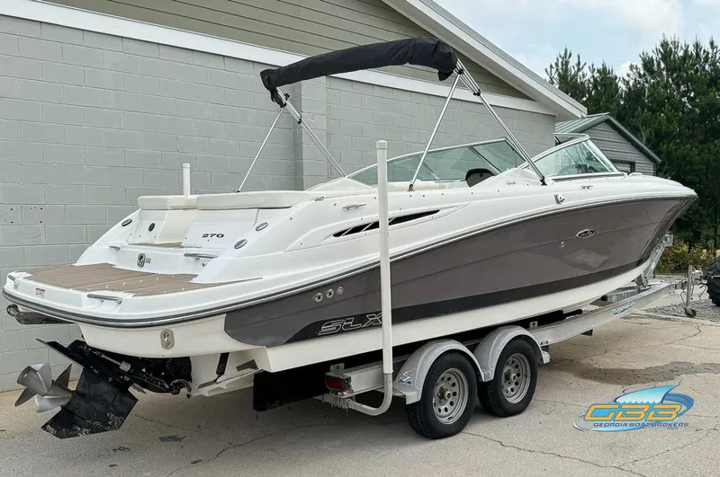 Slide: The Image of 2008 Sea Ray 270 SLX boat on trailer, parked outdoors near a building. - 2