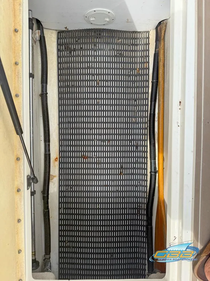 Slide: The Image of 2008 Sea Ray 270 SLX boat compartment with black mat and visible wiring. - 41