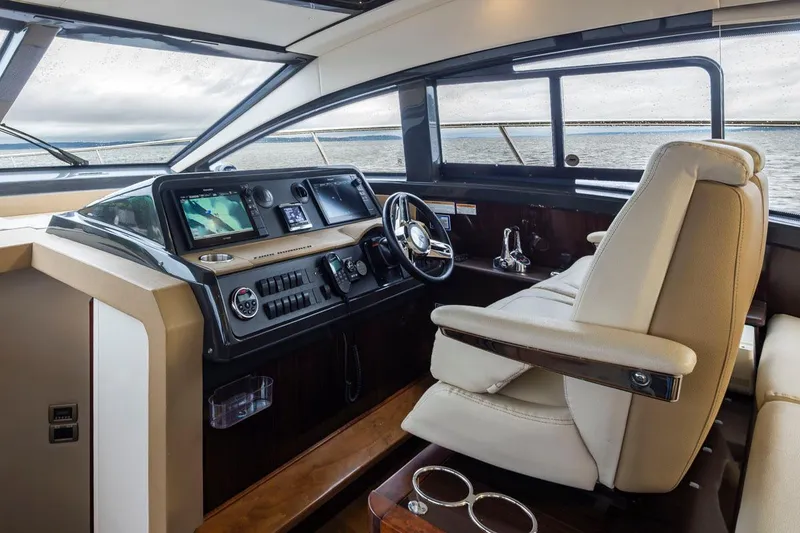 Slide: The Image of Interior of 2016 Sea Ray 400 Sundancer yacht, featuring modern helm and luxurious seating. - 14
