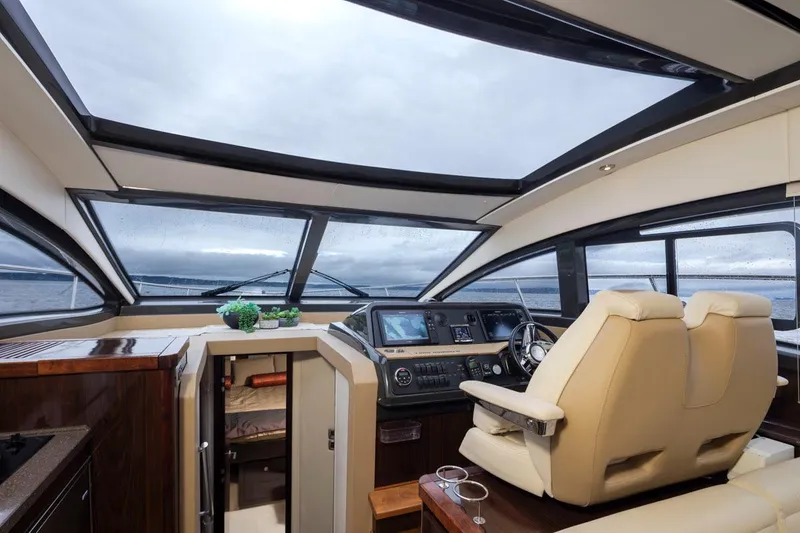 Slide: The Image of Interior of 2016 Sea Ray 400 Sundancer yacht with modern helm and panoramic windows. - 15