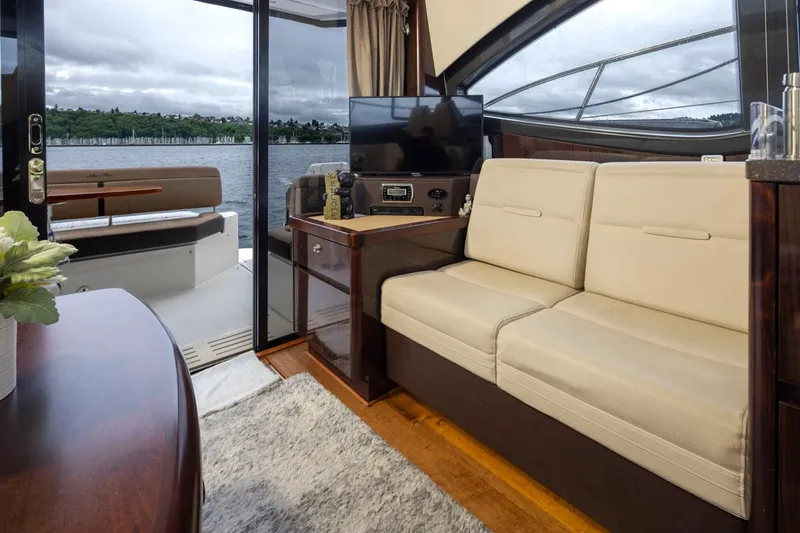 Slide: The Image of Interior of 2016 Sea Ray 400 Sundancer yacht with beige seating and lake view. - 24
