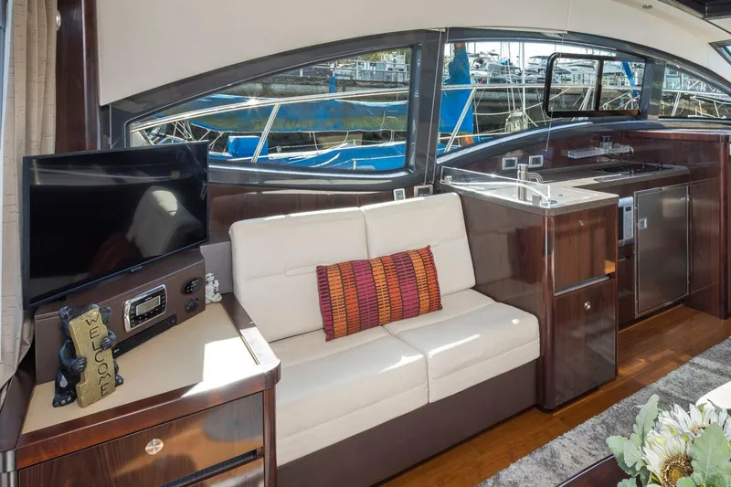 Slide: The Image of Interior of 2016 Sea Ray 400 Sundancer yacht with sofa, TV, and kitchenette. - 26