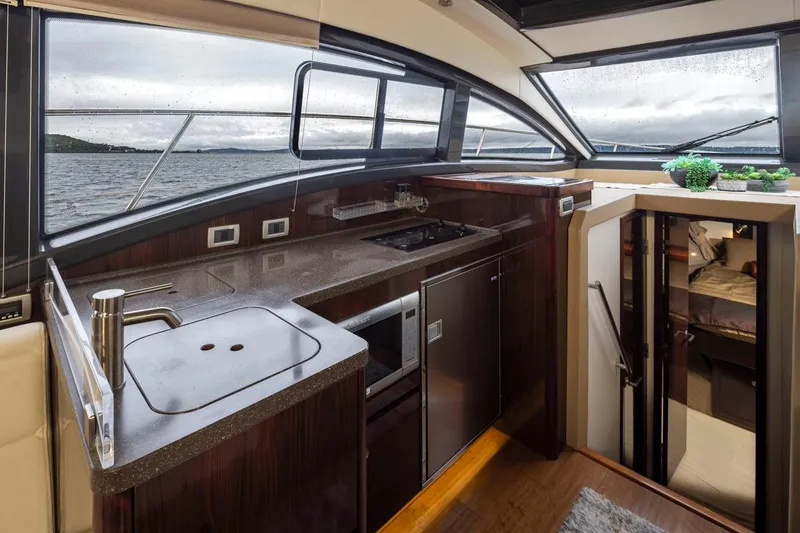 Slide: The Image of Interior of 2016 Sea Ray 400 Sundancer yacht with modern kitchen and scenic windows. - 29