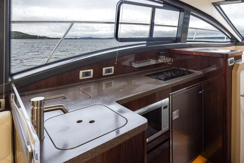 Slide: The Image of Interior view of 2016 Sea Ray 400 Sundancer yacht kitchen with sleek design and ocean backdrop. - 30
