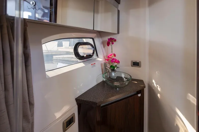 Slide: The Image of Interior of 2016 Sea Ray 400 Sundancer with window, countertop, and decorative flowers. - 40