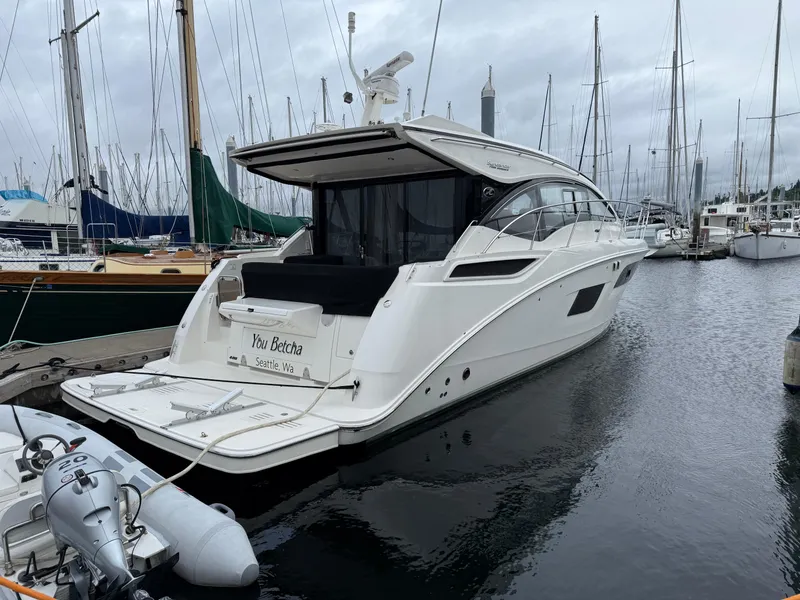 Slide: The Image of 2016 Sea Ray 400 Sundancer yacht docked in a marina, surrounded by sailboats. - 53