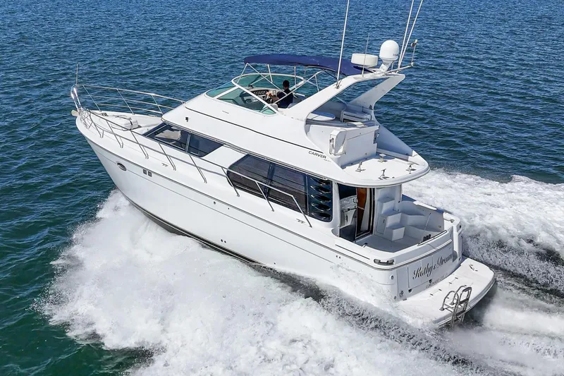 Slide: The Image of 2000 Carver 450 Voyager Pilothouse yacht cruising on open water. - 10
