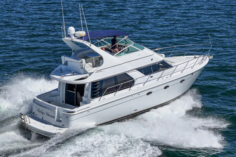 Slide: The Image of 2000 Carver 450 Voyager Pilothouse yacht cruising on open water. - 11