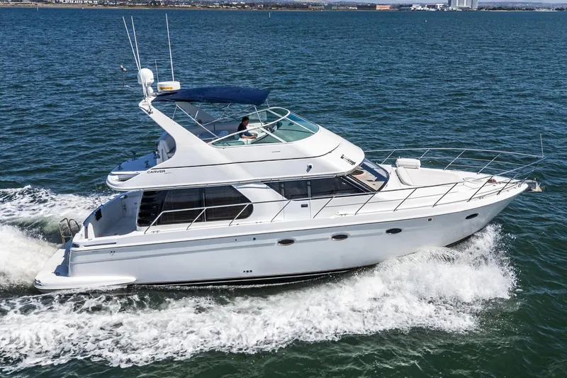 Slide: The Image of 2000 Carver 450 Voyager Pilothouse yacht cruising on open water. - 12