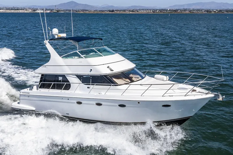 Slide: The Image of 2000 Carver 450 Voyager Pilothouse yacht cruising on open water. - 14