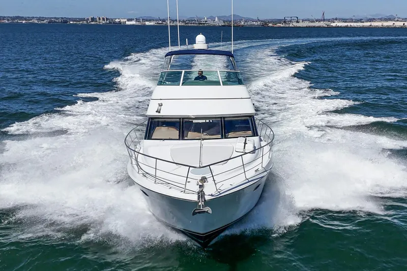Slide: The Image of 2000 Carver 450 Voyager Pilothouse cruising on open water, creating a dynamic wake. - 21