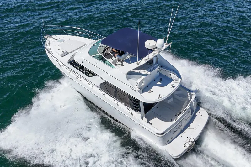 Slide: The Image of 2000 Carver 450 Voyager Pilothouse cruising on open water, aerial view. - 22