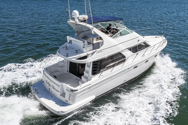 Slide: The Image of 2000 Carver 450 Voyager Pilothouse yacht cruising on open water. - 23