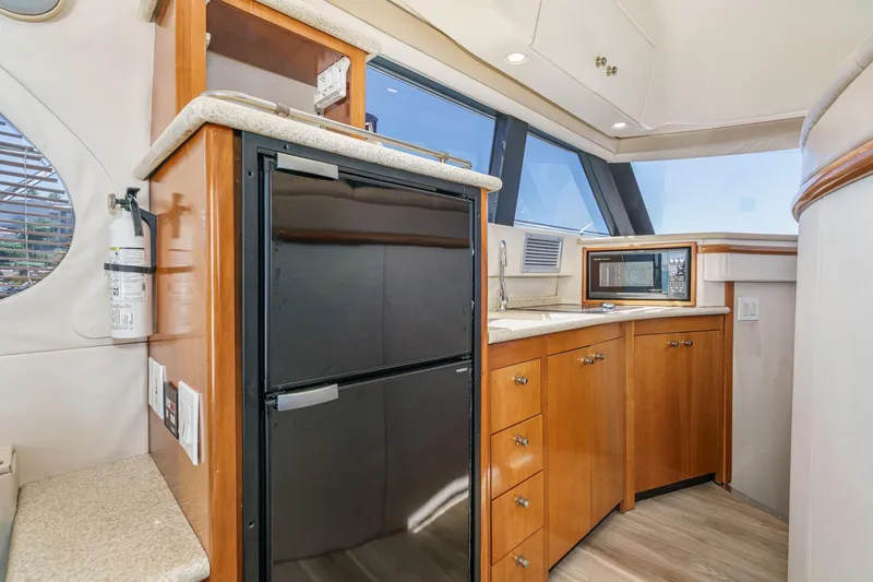 Slide: The Image of Interior of 2000 Carver 450 Voyager Pilothouse with kitchenette, fridge, and microwave. - 42