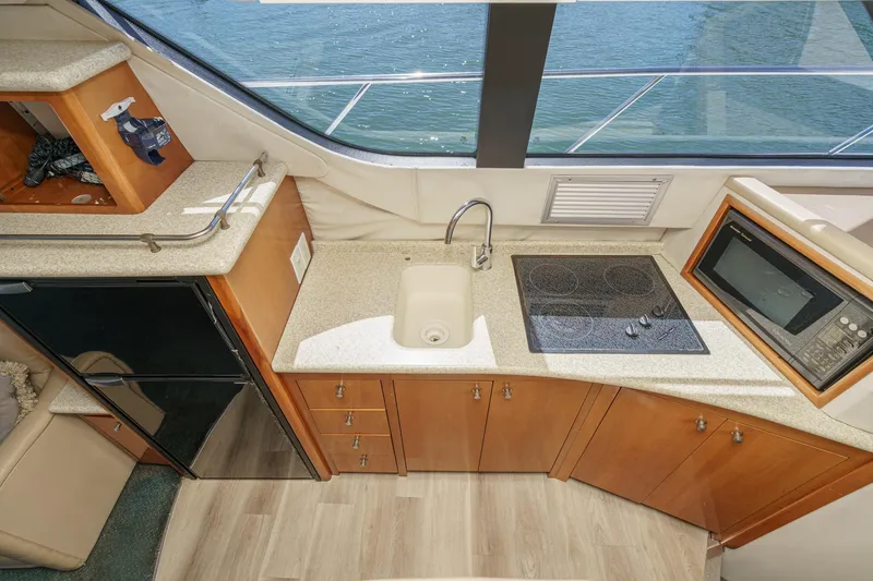 Slide: The Image of Kitchen area of 2000 Carver 450 Voyager Pilothouse with sink, stove, and microwave. - 43