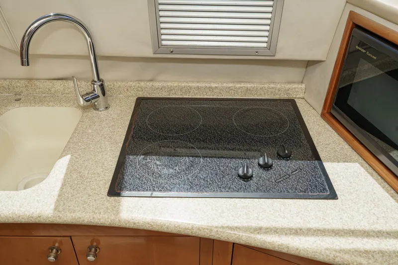 Slide: The Image of Modern kitchen area in 2000 Carver 450 Voyager Pilothouse with stovetop and sink. - 44