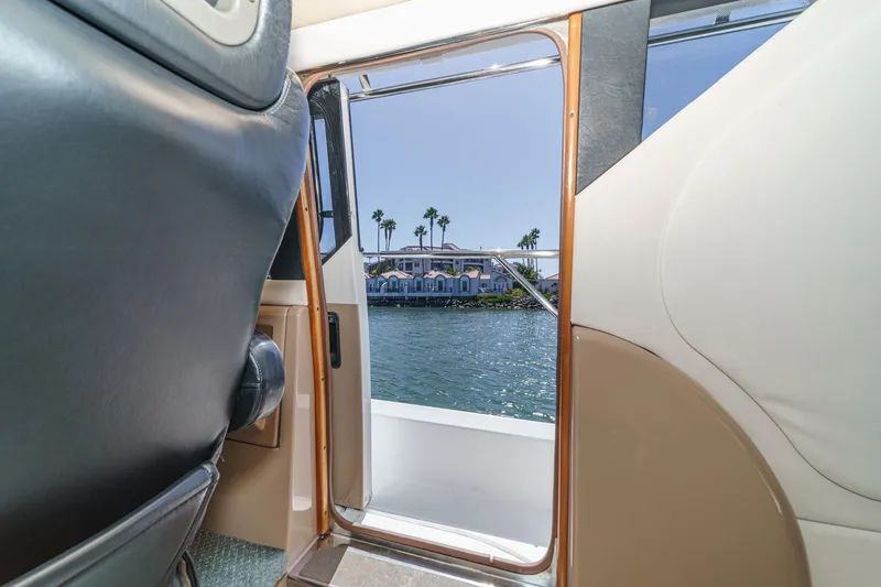 Slide: The Image of Interior view from a 2000 Carver 450 Voyager Pilothouse, overlooking water and palm trees. - 51