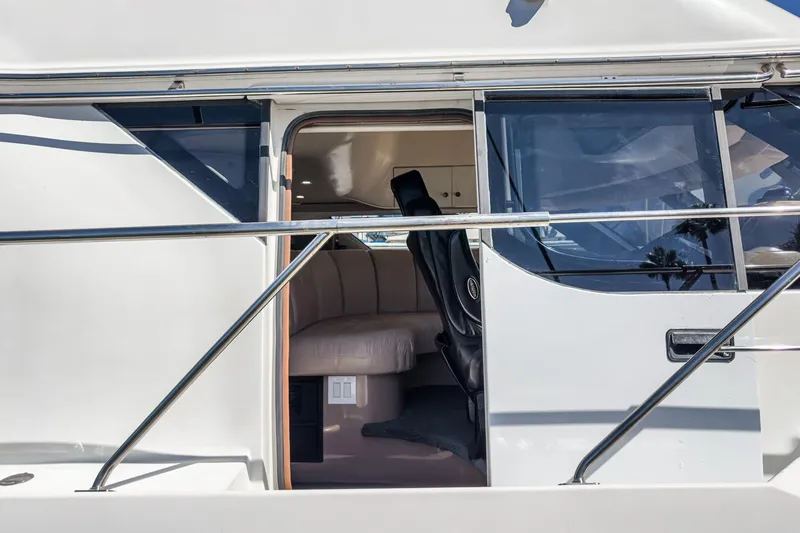 Slide: The Image of 2000 Carver 450 Voyager Pilothouse interior view with seating and windows. - 52