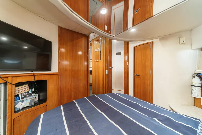 Slide: The Image of Interior of 2000 Carver 450 Voyager Pilothouse with wood paneling and striped bedding. - 54
