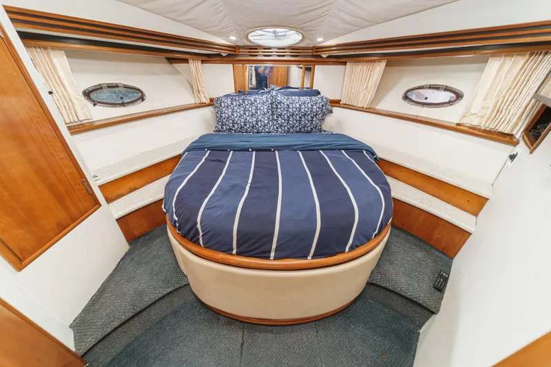 Slide: The Image of Luxurious 2000 Carver 450 Voyager Pilothouse bedroom with cozy bedding and elegant wood accents. - 57