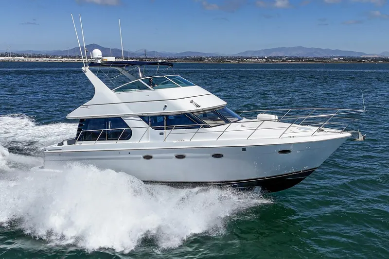 Slide: The Image of 2000 Carver 450 Voyager Pilothouse yacht cruising on open water. - 7