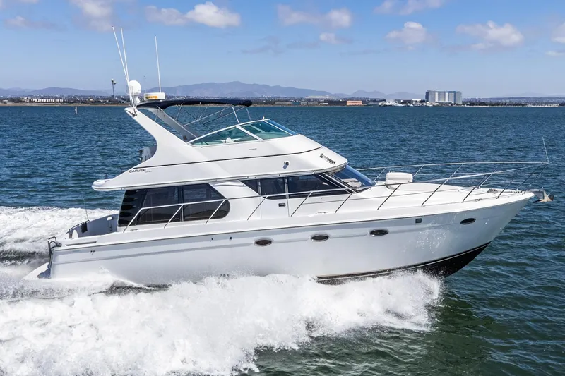 Slide: The Image of 2000 Carver 450 Voyager Pilothouse yacht cruising on open water. - 8