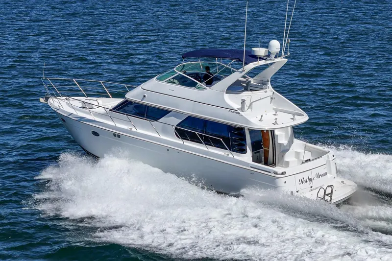 Slide: The Image of 2000 Carver 450 Voyager Pilothouse yacht cruising on open water. - 9