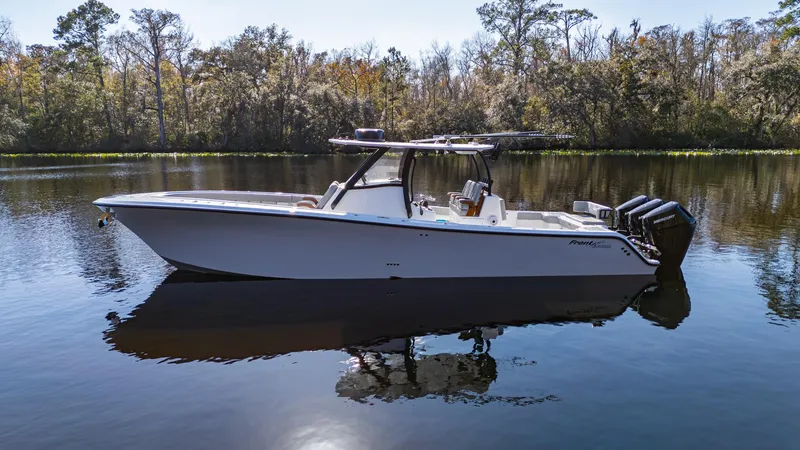 The Image of 2026 Front Runner 36 Center Console boat on calm water, surrounded by trees. - 1
