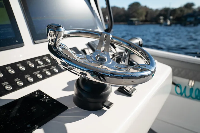 Slide: The Image of 2026 Front Runner 36 Center Console steering wheel with control panel, overlooking water. - 14