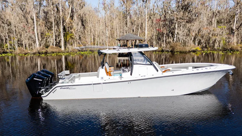 Slide: The Image of 2026 Front Runner 36 Center Console boat on calm water, surrounded by trees. - 4