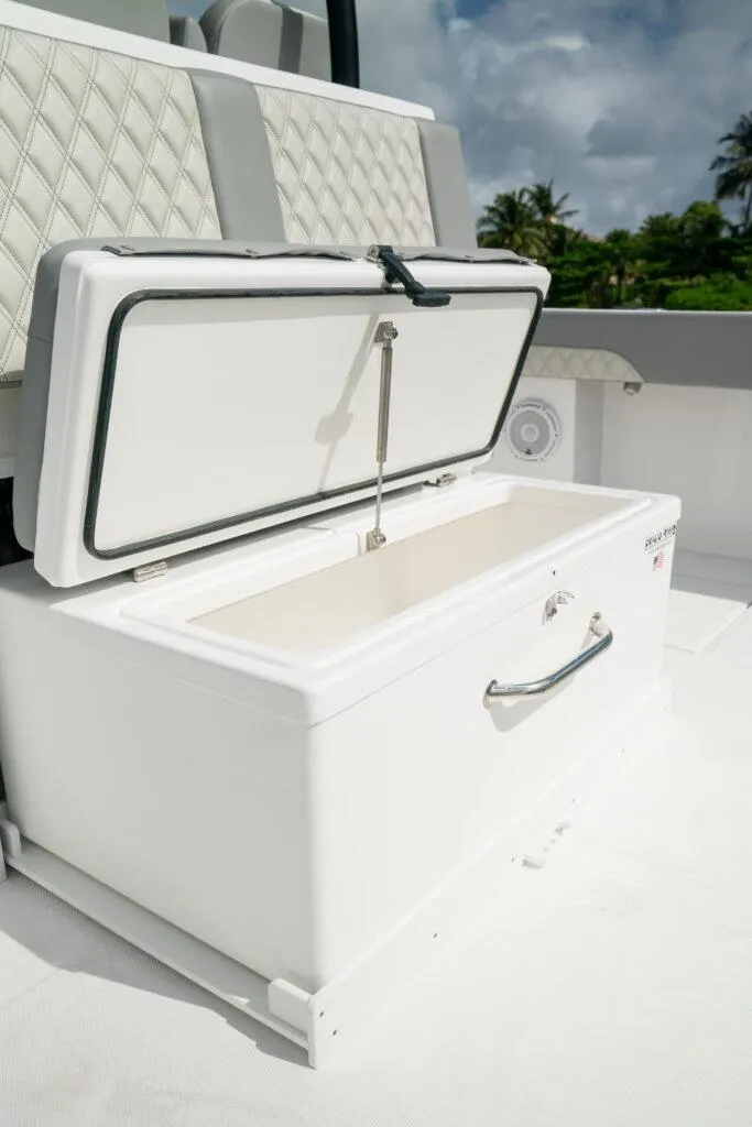 Slide: The Image of Open storage compartment on 2026 Front Runner 37 Catamaran, featuring quilted seating and tropical backdrop. - 22