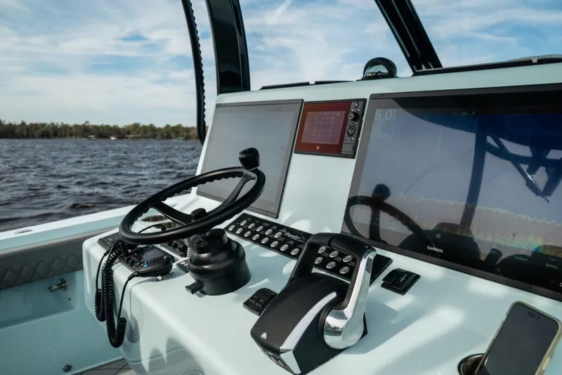 Slide: The Image of 2026 Front Runner 39 Center Console boat dashboard with steering wheel and navigation screens. - 48